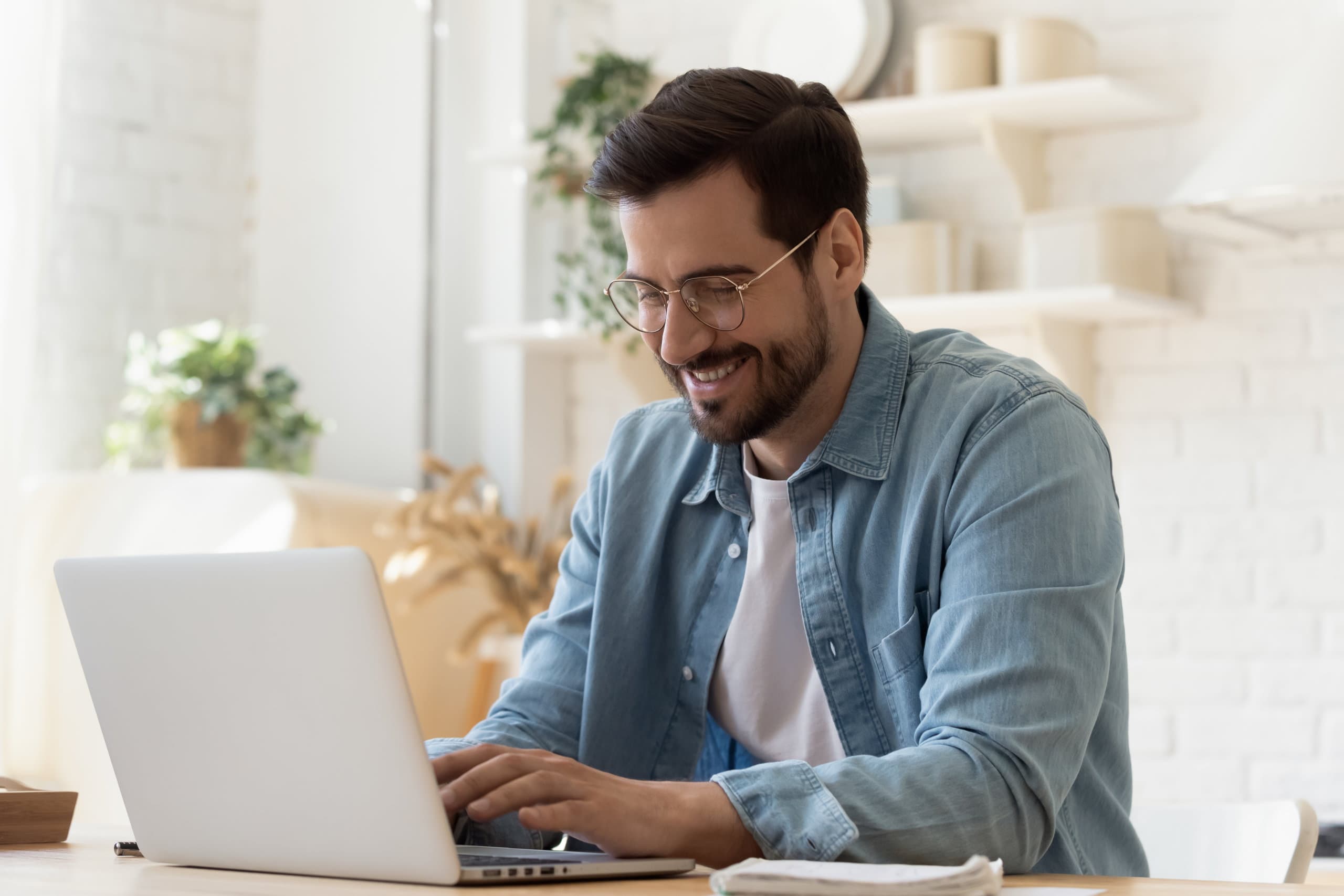 Man in denim jacket on laptop device